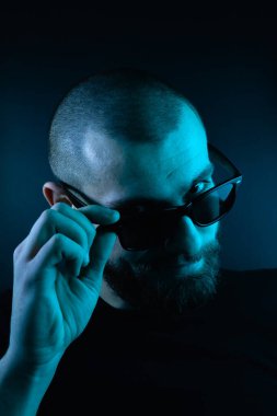 Renkli ışıklı bir hipster portresi. Stüdyoda hippi portresi.