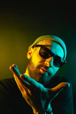 Renkli ışıklı bir hipster portresi. Stüdyoda hippi portresi.