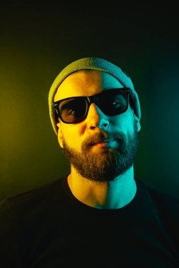 Renkli ışıklı bir hipster portresi. Stüdyoda hippi portresi.