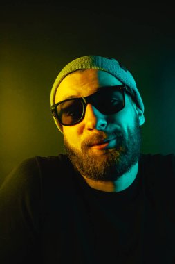 Renkli ışıklı bir hipster portresi. Stüdyoda hippi portresi.