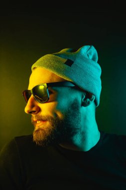 Renkli ışıklı bir hipster portresi. Stüdyoda hippi portresi.