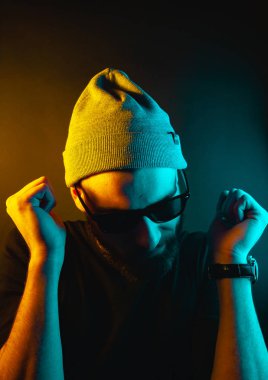 Renkli ışıklı bir hipster portresi. Stüdyoda hippi portresi.