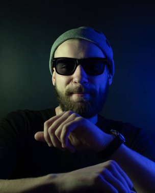 Renkli ışıklı bir hipster portresi. Stüdyoda hippi portresi.