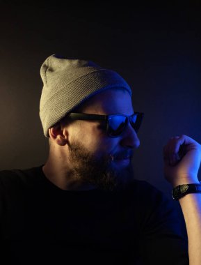 Renkli ışıklı bir hipster portresi. Stüdyoda hippi portresi.