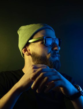 Renkli ışıklı bir hipster portresi. Stüdyoda hippi portresi.