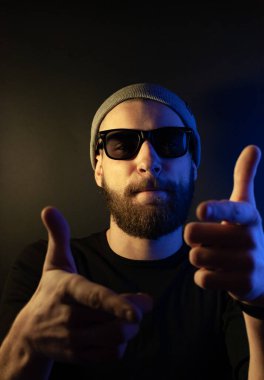 Renkli ışıklı bir hipster portresi. Stüdyoda hippi portresi.