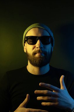 Renkli ışıklı bir hipster portresi. Stüdyoda hippi portresi.