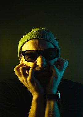 Renkli ışıklı bir hipster portresi. Stüdyoda hippi portresi.