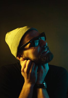 Renkli ışıklı bir hipster portresi. Stüdyoda hippi portresi.