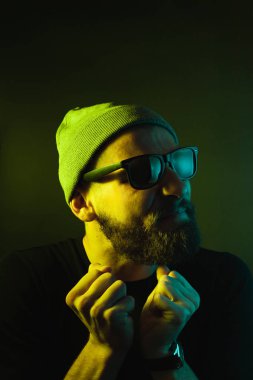 Renkli ışıklı bir hipster portresi. Stüdyoda hippi portresi.