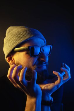 Renkli ışıklı bir hipster portresi. Stüdyoda hippi portresi.