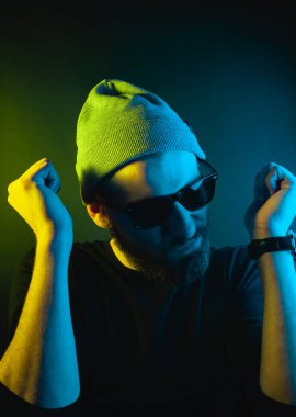 Renkli ışıklı bir hipster portresi. Stüdyoda hippi portresi.