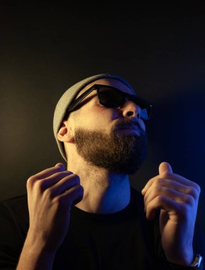 Renkli ışıklı bir hipster portresi. Stüdyoda hippi portresi.