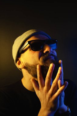 Renkli ışıklı bir hipster portresi. Stüdyoda hippi portresi.