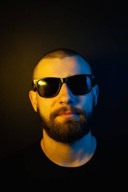 Renkli ışıklı bir hipster portresi. Stüdyoda hippi portresi.