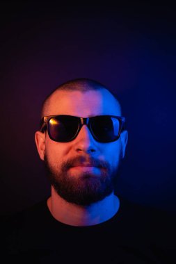 Renkli ışıklı bir hipster portresi. Stüdyoda hippi portresi.