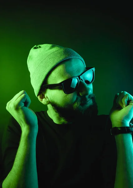 Portrait of a hipster guy with color light. Hipster face portrait in studio.