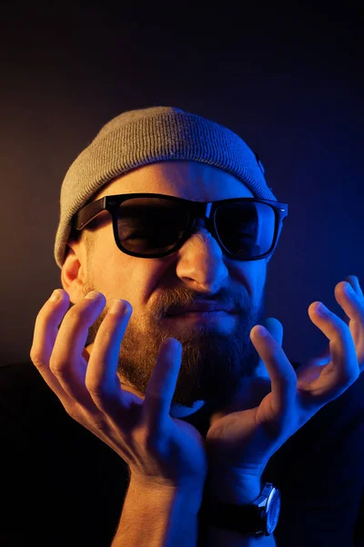 Portrait of a hipster guy with color light. Hipster face portrait in studio.