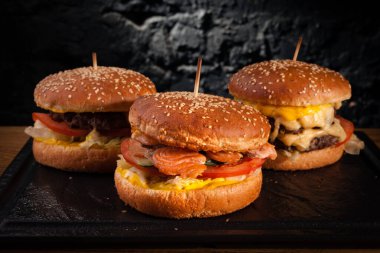 Bir güvertede farklı hamburgerlerin menüsü. Bir balık burger, hamburger ve peynirli burgerin yan görüntüsü..