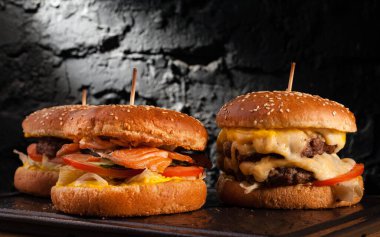 Bir güvertede farklı hamburgerlerin menüsü. Bir balık burger, hamburger ve peynirli burgerin yan görüntüsü..