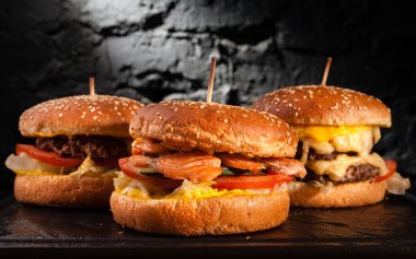 Bir güvertede farklı hamburgerlerin menüsü. Bir balık burger, hamburger ve peynirli burgerin yan görüntüsü..