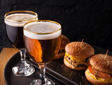 Bardakta soğuk bira ve sulu büyük hamburger şeklinde atıştırmalık. Fast food.