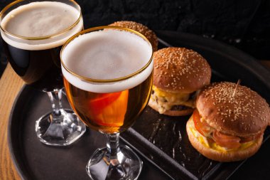 Bardakta soğuk bira ve sulu büyük hamburger şeklinde atıştırmalık. Fast food.