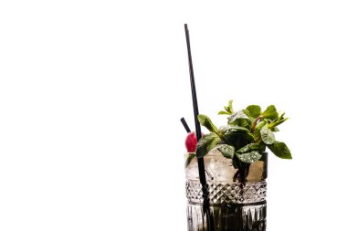 Mojito bardağa yakın çekim içer, izole eder. Buzlu, ferahlatıcı bir içeceğin içeriğine yakın çekim. Nane yaprağı, kireç dilimi, buz, çilekli saman.