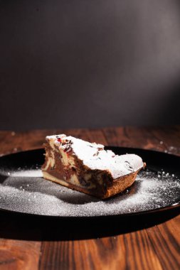 Üzerine krema serpiştirilmiş çikolatalı pasta. Tahta masadaki çikolatalı pasta..