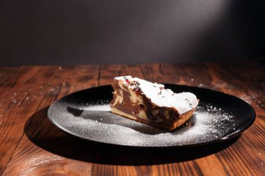 Üzerine krema serpiştirilmiş çikolatalı pasta. Tahta masadaki çikolatalı pasta..