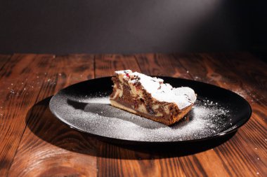 Üzerine krema serpiştirilmiş çikolatalı pasta. Tahta masadaki çikolatalı pasta..