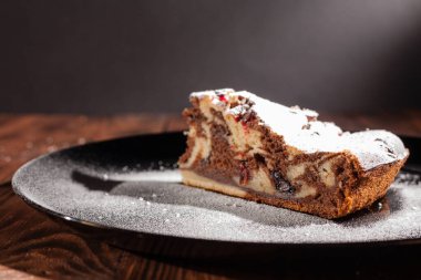 Üzerine krema serpiştirilmiş çikolatalı pasta. Tahta masadaki çikolatalı pasta..