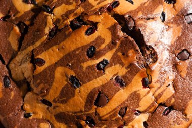 Üzerine krema serpiştirilmiş çikolatalı pasta. Tahta masadaki çikolatalı pasta..