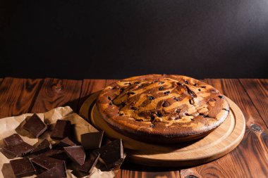 Üzerine krema serpiştirilmiş çikolatalı pasta. Tahta masadaki çikolatalı pasta..