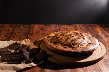 Üzerine krema serpiştirilmiş çikolatalı pasta. Tahta masadaki çikolatalı pasta..