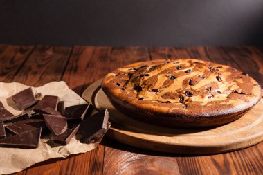 Üzerine krema serpiştirilmiş çikolatalı pasta. Tahta masadaki çikolatalı pasta..