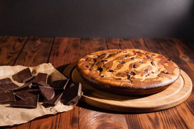 Üzerine krema serpiştirilmiş çikolatalı pasta. Tahta masadaki çikolatalı pasta..