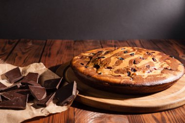 Üzerine krema serpiştirilmiş çikolatalı pasta. Tahta masadaki çikolatalı pasta..