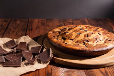 Üzerine krema serpiştirilmiş çikolatalı pasta. Tahta masadaki çikolatalı pasta..