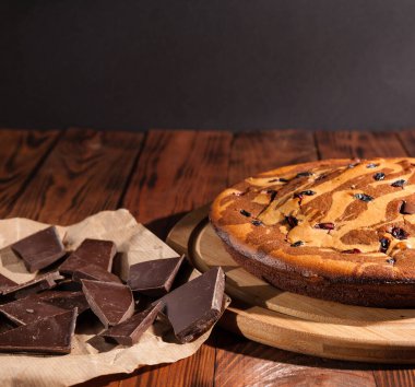 Üzerine krema serpiştirilmiş çikolatalı pasta. Tahta masadaki çikolatalı pasta..