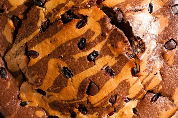 Üzerine krema serpiştirilmiş çikolatalı pasta. Tahta masadaki çikolatalı pasta..