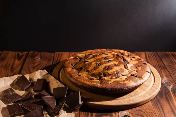 Üzerine krema serpiştirilmiş çikolatalı pasta. Tahta masadaki çikolatalı pasta..