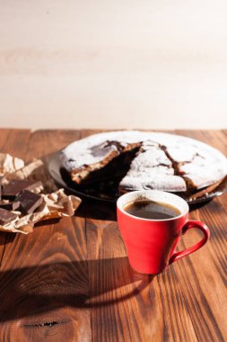 Tahta bir masada çikolatalı kahve ve pasta tatlısı..