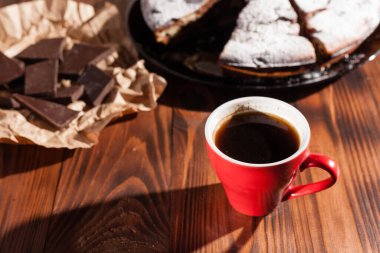 Tahta bir masada çikolatalı kahve ve pasta tatlısı..