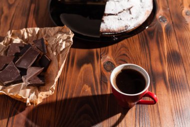 Tahta bir masada çikolatalı kahve ve pasta tatlısı..