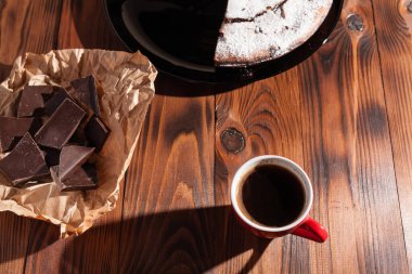 Tahta bir masada çikolatalı kahve ve pasta tatlısı..