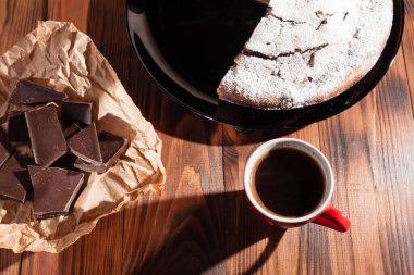 Tahta bir masada çikolatalı kahve ve pasta tatlısı..