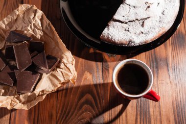 Tahta bir masada çikolatalı kahve ve pasta tatlısı..