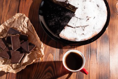 Tahta bir masada çikolatalı kahve ve pasta tatlısı..