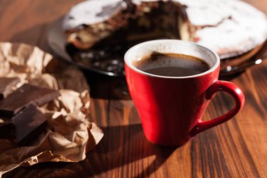 Tahta bir masada çikolatalı kahve ve pasta tatlısı..